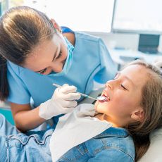 Beautiful girl at the dentist getting a check up on her teeth - pediatrics dental care concepts